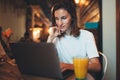 Female manager using laptop in cafe interior, hipster girl freelancer looking on computer monitor, businesswoman working Royalty Free Stock Photo