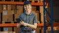 Female Manager Using Tablet Computer To Check Inventory, Smiles and Looks at Camera. Warehouse Royalty Free Stock Photo