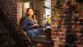 Female Manager Writing her Work Emails Using a Laptop While Sitting on her Windowsill. Young Royalty Free Stock Photo