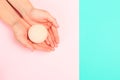 Female  manicure. Beautiful young woman`s hands holding a bathroom bomb on pastel background Royalty Free Stock Photo