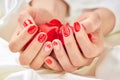 Female manicured hands with rose petals. Royalty Free Stock Photo