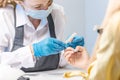 Female manicurist doing a manicure by working with the nail salon. Concept of beauty professional nail care Royalty Free Stock Photo