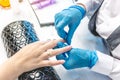 Female manicurist doing a manicure by working with the nail salon. Concept of beauty professional nail care Royalty Free Stock Photo