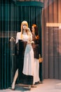 Female mannequin in shop window showcase of store mall market. Fashion clothes - dress, jacket. Mannequins dressed in Royalty Free Stock Photo