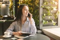 Female marketing manager making mobile negotiating in cafe