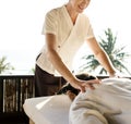 Female massage therapist giving a massage at a spa