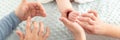 Female massage therapist teaching young mother how to massage her newborn baby boy. Baby massage concept. Cropped shot.