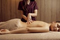 Female masseur pampering back to woman, massage