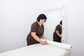 Female masseuse cuts a piece of disposable sheet before massage procedure Royalty Free Stock Photo