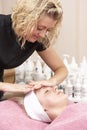 Female masseuse giving client facial