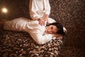 Female masseuse makes massage to woman in sauna