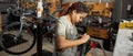 Female master fixing bike tube in bicycle workshop