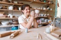 Female master paints a pot, pottery workshop