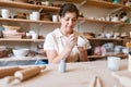Female master paints a pot, pottery workshop