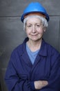 Female mature technician wearing a blue hard hat and a uniform Royalty Free Stock Photo