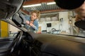 Female mechanic changing windscreen on car