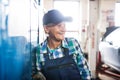 Senior female mechanic repairing a car in a garage. Royalty Free Stock Photo