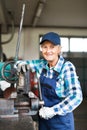 Senior female mechanic repairing a car in a garage. Royalty Free Stock Photo