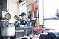 Senior female mechanic repairing a car in a garage. Royalty Free Stock Photo