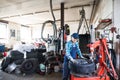 Senior female mechanic repairing a car in a garage. Royalty Free Stock Photo