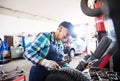 Senior female mechanic repairing a car in a garage. Royalty Free Stock Photo