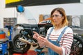 Female mechanic with security glasses touching transparent tablet Royalty Free Stock Photo