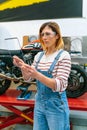 Female mechanic with security glasses touching transparent tablet Royalty Free Stock Photo