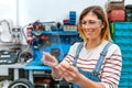 Female mechanic with security glasses touching transparent tablet Royalty Free Stock Photo