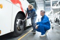 Female mechanic using tonque wrench on bus wheel nuts Royalty Free Stock Photo