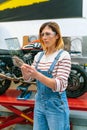 Female mechanic using transparent digital tablet with motorcycle diagnosis app Royalty Free Stock Photo