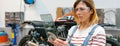 Female mechanic using transparent digital tablet with motorcycle diagnosis app