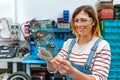 Female mechanic using transparent digital tablet with motorcycle diagnosis app Royalty Free Stock Photo