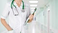 Female medical doctor with clipboard standing over blurry hospital background