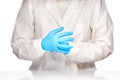 Female medical doctor pulling on blue gloves