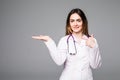 Female medical doctor showing copy space. Woman in white professional uniform with stethoscope on neck.