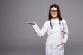 Female medical doctor showing copy space. Woman in white professional uniform with stethoscope on neck invite people to clinic hos Royalty Free Stock Photo