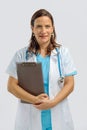 Female medical doctor wearing white medical gown with stethoscope holding clip board Royalty Free Stock Photo