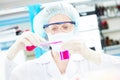 Female medical scientific researcher holding flask