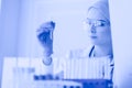 A female medical or scientific researcher or woman doctor looking at a test tube of clear solution in a laboratory Royalty Free Stock Photo