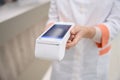 Female medical worker holds terminal for paying for medical services Royalty Free Stock Photo