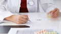 Female medicine doctor fills up prescription form to patient closeup. Panacea and life save, prescribe treatment, lega Royalty Free Stock Photo