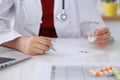 Female medicine doctor fills up prescription form to patient closeup. Panacea and life save, prescribe treatment, lega Royalty Free Stock Photo