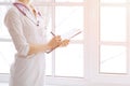 Female medicine doctor hand holding pen writing something on clipboard closeup. Royalty Free Stock Photo