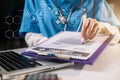 Female medicine doctor hand holding silver pen writing something on clipboard close up. Royalty Free Stock Photo