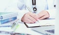 Young female medicine doctor hand holding silver pen writing something on clipboard closeup. Royalty Free Stock Photo