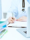 Young female medicine doctor hand holding silver pen writing something on clipboard closeup. Royalty Free Stock Photo