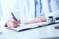 Female medicine doctor hand holding silver pen writing something on clipboard closeup.. Ward round, patient visit check Royalty Free Stock Photo