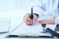 Female medicine doctor hand holding silver pen writing something on clipboard closeup.. Ward round, patient visit check Royalty Free Stock Photo
