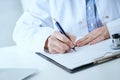 Female medicine doctor hand holding silver pen writing something on clipboard closeup.. Ward round, patient visit check Royalty Free Stock Photo