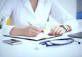 Female medicine doctor hand holding silver pen writing something on clipboard and working laptop closeup. Physician Royalty Free Stock Photo